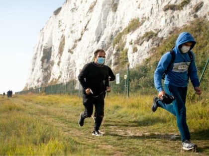 DEAL, ENGLAND - SEPTEMBER 15: Migrants run inland after landing on a beach on September 15