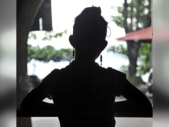 One of the five teenage girls rescued from a cyber sex den is sillhouetted in this photo taken at Preda Foundation office on December 2, 2010 in Olongapo City. Orders were streaming in when police barged in at a house in the northern Philippines, where naked girls manning computers acted …