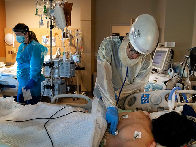 FILE - In this Nov. 19, 2020, file photo, Dr. Rafik Abdou checks on a COVID-19 patient at Providence Holy Cross Medical Center in the Mission Hills section of Los Angeles. All of Southern California and the 12-county San Joaquin Valley to the north have exhausted their regular ICU capacity, …