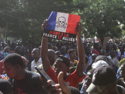 A man holds up a sign reading in French "death to France and allies" during a gathering outside the Great Mosque of Bamako on October 28, 2020, called to condemn French President Emmanuel Macron remarks after he has strongly defended secular values and the right to mock religion following the …