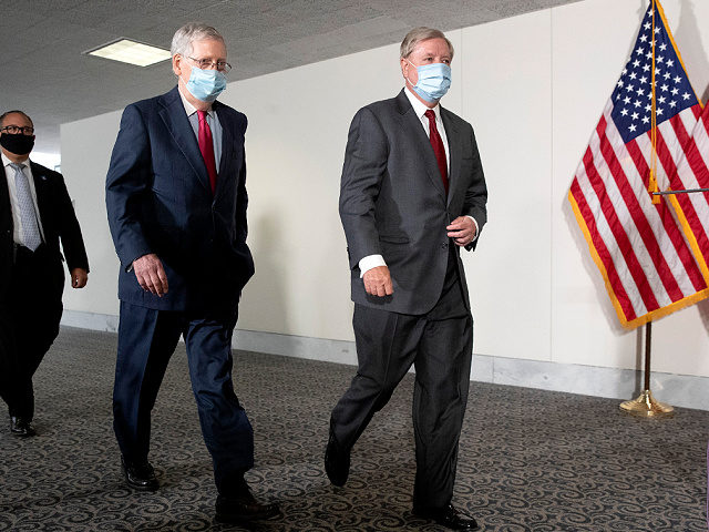 Senate Majority Leader Mitch McConnell of Ky., left, and Sen. Lindsey Graham, R-S.C., wear face masks to protect against the spread of the new coronavirus as they arrive for a weekly luncheon on Capitol Hill in Washington, Tuesday, May 19, 2020. (AP Photo/Patrick Semansky)