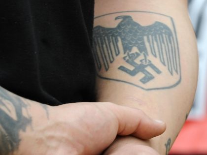 A Nazi-symbol tattooed member of Spain's ultra right party Alianza Nacional attends a rally held for celebrations as part of the Dia de la Hispanidad, (Spain's National Holiday) in Tarragona on October 12, 2008. AFP PHOTO/LLUIS GENE. (Photo credit should read LLUIS GENE/AFP via Getty Images)