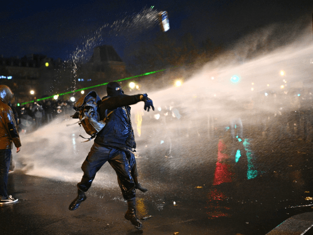 TOPSHOT - A protester throws an object during a demonstration …