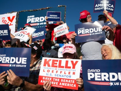 AUGUSTA, GA - DECEMBER 10: Supporters hold signs and wait for the start of a rally with Vice President Mike Pence as he lends support for Sen. David Purdue (R-GA) and Sen. Kelly Loeffler (R-GA) on December 10, 2020 in Augusta, Georgia. The "Defend the Majority" rally comes ahead of …