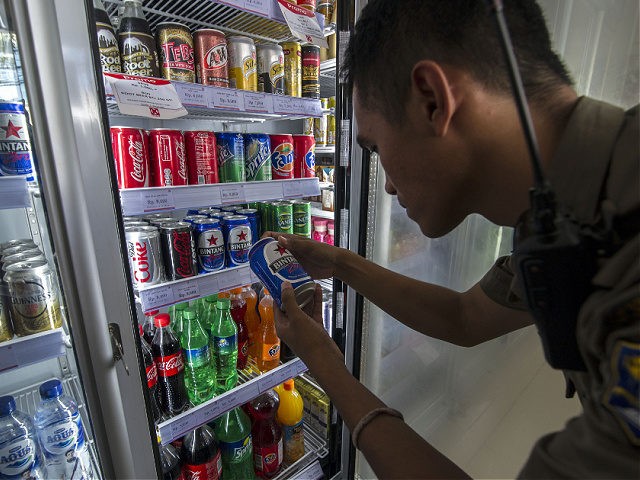 A local civil security personnel inspects the cold drinks section at a mini mart in Suraba