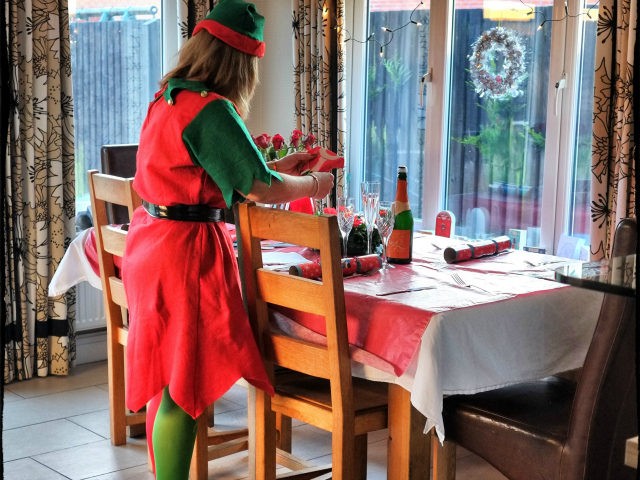 (EDITORS NOTE: This images was created using digital filter) A woman wears an elf suit as she sets the Christmas table on December 25, 2014 in Glasgow, Scotland. Millions of people across the UK spend time with family and loved ones on Christmas day, traditionally exchanging gifts and eating and …