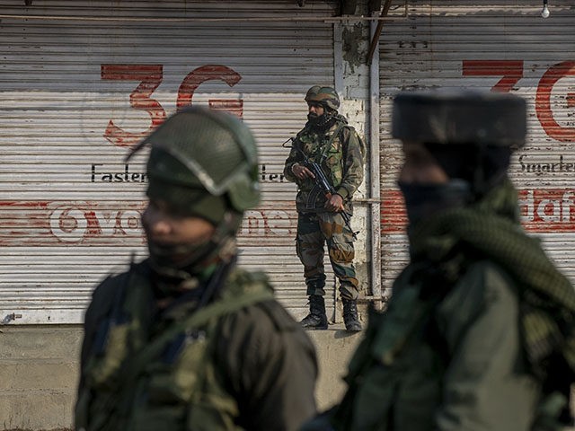 Indian army soldiers look towards the site of a gun battle on the outskirts of Srinagar, I