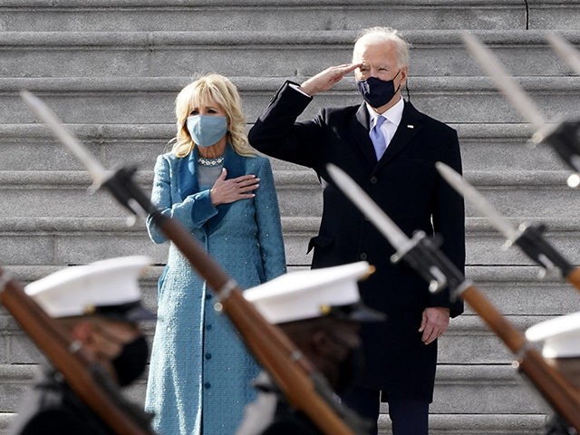 President Joe Biden and his wife Jill Biden watch a military pass in review ceremony on the East Front of the Capitol at the conclusion of the inauguration ceremonies, in Washington, Wednesday, Jan. 20, 2021. (AP Photo/J. Scott Applewhite)