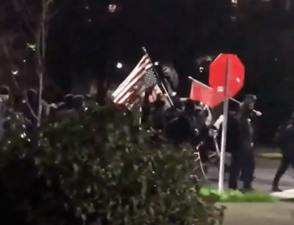 Antifa protesters in Seattle march in the street, burn a flag, and vandalize businesses. (Twitter Video Screenshot/Jonathan Choe KOMO)