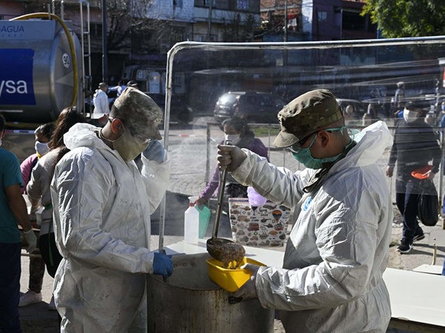 Members of the Argentine Army serve stew on a street for residents of the Villa 1-11-14 shantytown during the lockdown imposed by the government against the spread of the new coronavirus, COVID-19, in Buenos Aires, on May 26, 2020. (Photo by JUAN MABROMATA / AFP) (Photo by JUAN MABROMATA/AFP via …