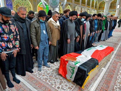 Iraqi mourners pray over the coffin of a victim who was killed in a twin suicide bombing in central Baghdad, during a funeral in the holy city of Najaf on January 21, 2021. - A rare twin suicide bombing killed 32 people and wounded 110 at a crowded market in …