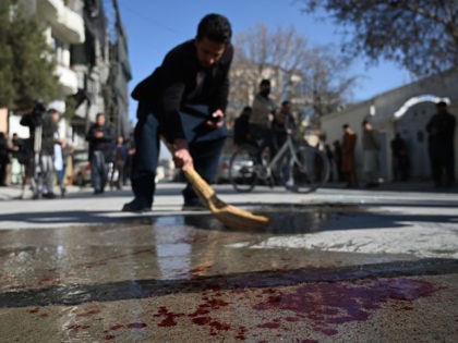 A resident washes a road following gunmen shot dead two Afghan women judges working for the Supreme Court, in Kabul on January 17, 2021. - Gunmen shot dead two Afghan women judges working for the Supreme Court during an early morning ambush in the country's capital on January 17, officials …