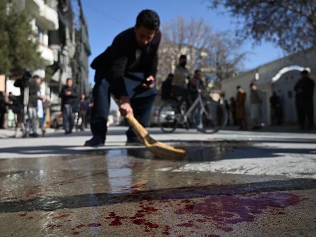 A resident washes a road following gunmen shot dead two Afghan women judges working for the Supreme Court, in Kabul on January 17, 2021. - Gunmen shot dead two Afghan women judges working for the Supreme Court during an early morning ambush in the country's capital on January 17, officials said, as a wave of assassinations continues to rattle the nation. (Photo by WAKIL KOHSAR / AFP) (Photo by WAKIL KOHSAR/AFP via Getty Images)