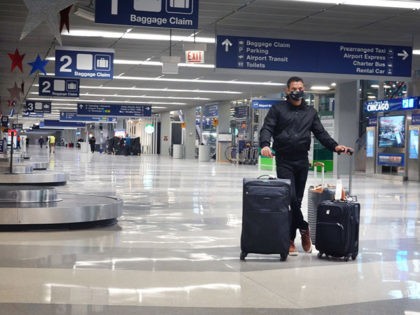 CHICAGO, ILLINOIS - NOVEMBER 25: A traveler passes through O'Hare International Airport on November 25, 2020 in Chicago, Illinois. Although airports are expecting fewer than half the number of travelers from Thanksgiving 2019, they are anticipating the largest number of travelers since March when the COVID-19 pandemic became widespread in …
