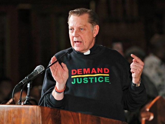 Father Michael Pfleger speaks as he introduces Nation of Islam leader Louis Farrakhan at S