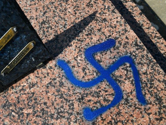 A picture taken on April 1, 2019 shows a grave vandalised with spray-painted swastikas at