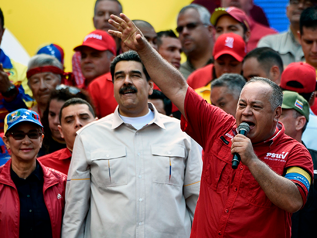 The president of the Venezuelan National Constituent Assembly Diosdado Cabello (R) speaks next to Venezuela's President Nicolas Maduro and First Lady Cilia Flores (L) during a rally at the Miraflores Palace in Caracas, Venezuela on April 6, 2019. - Venezuela's opposition leader Juan Guaido urged his supporters to demonstrate to …