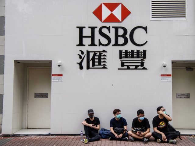 Protesters sit outside a HSBC in the Kowloon district of Hong Kong on August 11, 2019, in the latest opposition to a planned extradition law that was quickly evolved into a wider movement for democratic reforms. - Thousands of pro-democracy protesters hit the streets of Hong Kong for a tenth …