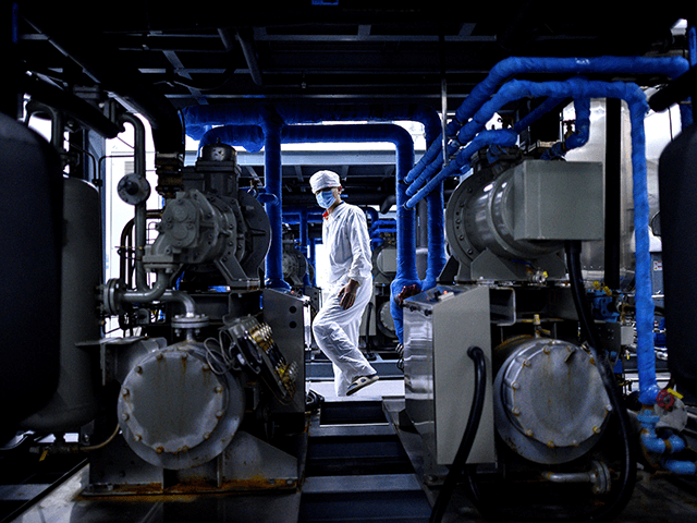 A worker wearing a protective suit walks at a lab of the Yisheng Biopharma company Yisheng Biopharma company, where researchers are trying to develop a vaccine for the COVID-19 coronavirus, in Shenyang, in Chinas northeast Liaoning province, on June 9, 2020. - China has mobilised its army and fast-tracked tests …