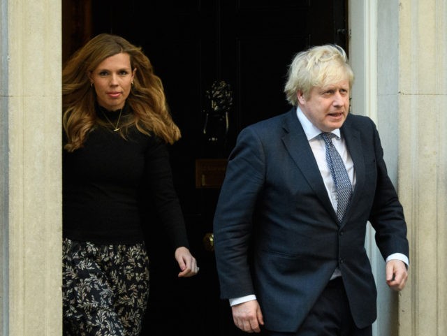 LONDON, UNITED KINGDOM - MAY 14: Britain's Prime Minister Boris Johnson and his partner Carrie Symonds stand outside the door of number 10 Downing Street as they thank the key workers who are working during the current lockdown on May 14, 2020 in London, United Kingdom. Following the success of …