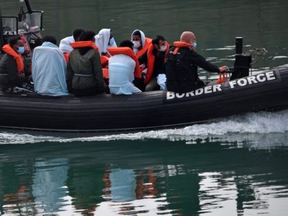 UK Border Force officials travel in a RIB with migrants picked up at sea whilst Crossing the English Channel, as they arrive at the Marina in Dover, southeast England on August 15, 2020. (Photo by Ben STANSALL / AFP) (Photo by BEN STANSALL/AFP via Getty Images)