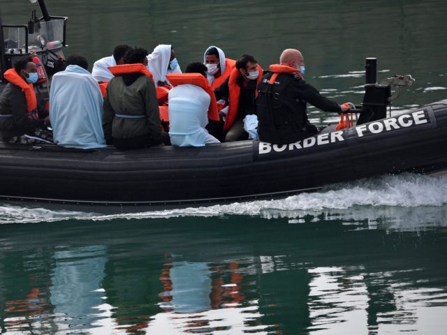 UK Border Force officials travel in a RIB with migrants picked up at sea whilst Crossing t