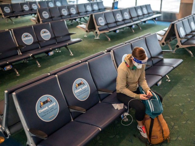 PORTLAND, OR - NOVEMBER 25: A traveler checks their phone while waiting for a flight at Portland International Airport on November 25, 2020 in Portland, Oregon. Millions of Americans traveled by plane ahead of the Thanksgiving holiday, despite the CDC recommending families stay home. (Photo by Nathan Howard/Getty Images)
