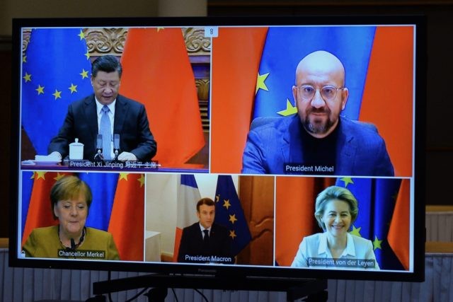 European Commission President Ursula von der Leyen, European Council President Charles Michel, German Chancellor Angela Merkel, French President Emmanuel Macron and Chinese President Xi Jinping are seen on a screen during a video conference to approve an investment pact between China and the European Union on December 30, 2020 in …