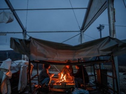 BIHAC, BOSNIA AND HERZEGOVINA - JANUARY 4: Migrants gather around fire at the burned down