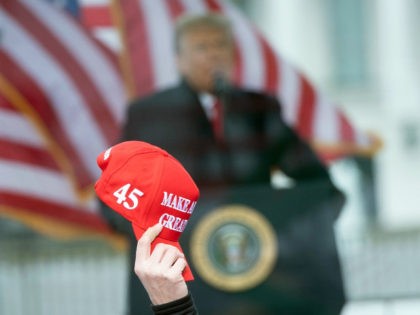 A person raises a "Make America Great" hat as US President Donald Trump speaks to supporters from The Ellipse near the White House on January 6, 2021, in Washington, DC. - Thousands of Trump supporters, fueled by his spurious claims of voter fraud, are flooding the nation's capital protesting the …