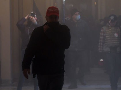 Supporters of US President Donald Trump enter the US Capitol as tear gas fills the corridor on January 6, 2021, in Washington, DC. - Demonstrators breeched security and entered the Capitol as Congress debated the a 2020 presidential election Electoral Vote Certification. (Photo by Saul LOEB / AFP) (Photo by …