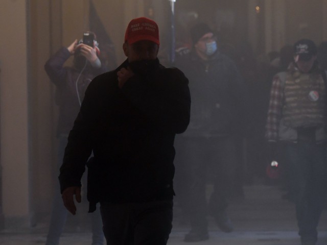 Supporters of US President Donald Trump enter the US Capitol as tear gas fills the corridor on January 6, 2021, in Washington, DC. - Demonstrators breeched security and entered the Capitol as Congress debated the a 2020 presidential election Electoral Vote Certification. (Photo by Saul LOEB / AFP) (Photo by SAUL LOEB/AFP via Getty Images)