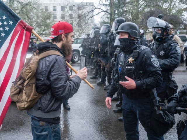 SALEM, OR - JANUARY 06: A supporter of President Trump speaks with riot police during a protest on January 6, 2021 in Salem, Oregon. Trump supporters gathered at state capitals across the country to protest today's ratification of Joe Biden's Electoral College victory over President Trump in the 2020 election. …