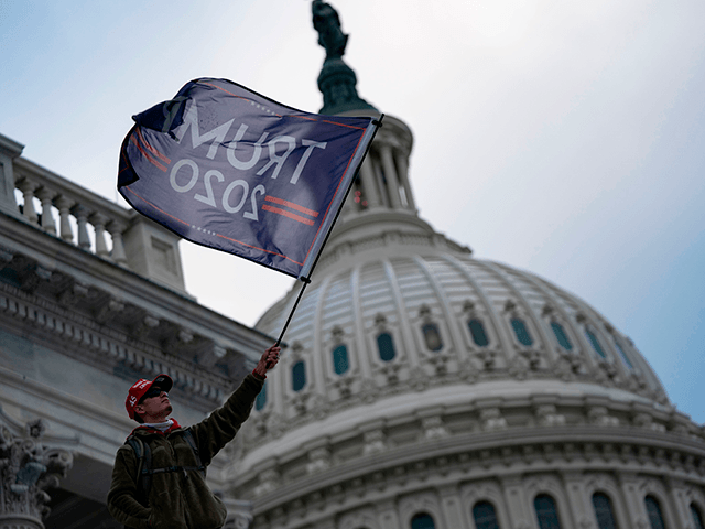 A person waves a Trump 2020 flag as supporters of US President Donald Trump protest outside the US Capitol on January 6, 2021, in Washington, DC. - Demonstrators breeched security and entered the Capitol as Congress debated the a 2020 presidential election Electoral Vote Certification. (Photo by ALEX EDELMAN / …