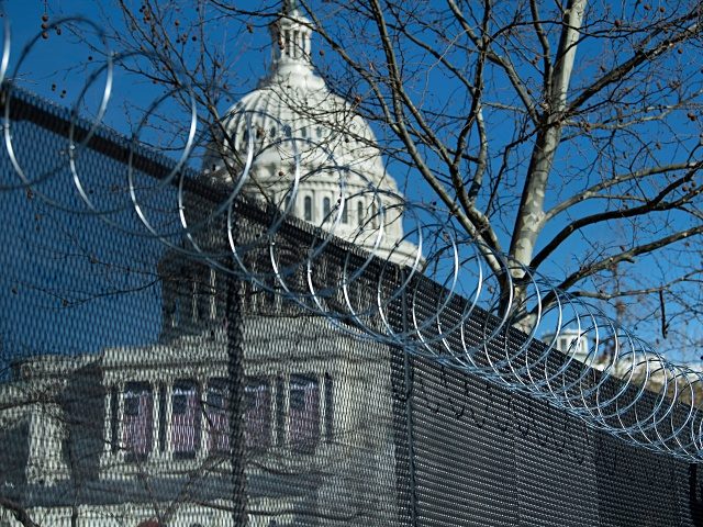 Razor wire is installed atop a security fence in preparation for next week's Presidential
