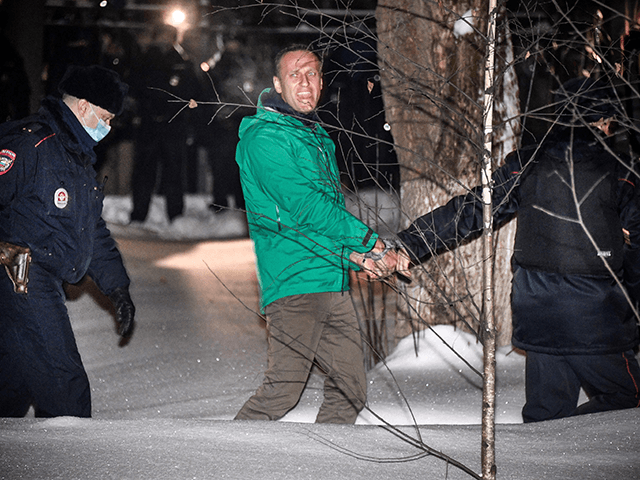 Opposition leader Alexei Navalny is escorted out of a police station on January 18, 2021,