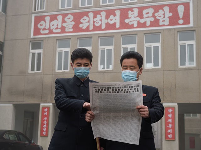 In a photo taken on January 21, 2021, officials of the Pyongyang City Committee of the Workers' Party of Korea (WPK) pose for a photo holding a newspaper carrying a report made by North Korean leader Kim Jong Un at the Eighth Congress of the WPK at an office in …