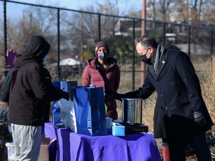 US Second Gentleman Doug Emhoff (R) speaks with volunteers of Dreaming out Loud, a nonprofit organization focused on food security and economic opportunity, during a visit to the Farm at Kelly Miller middle school, run by Dreaming Out Loud, in Washington, DC, on January 28, 2021. (Photo by NICHOLAS KAMM …