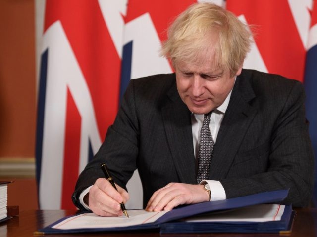 LONDON, ENGLAND - DECEMBER 30: Prime Minister, Boris Johnson signs a page of the Brexit tr