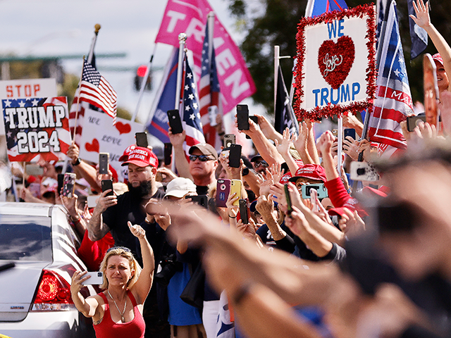 Supporters wave to outgoing US President Donald Trump as he returns to Florida along the r