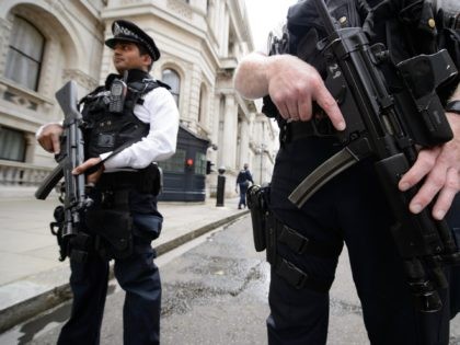 Armed police officers hold guns as they stand in Downing Street, in central London on August 29, 2014. British Home Secretary Theresa May said on August 29 the country's terror threat risk level was being raised to "severe" due to fears over the situation in Iraq and Syria. AFP PHOTO …