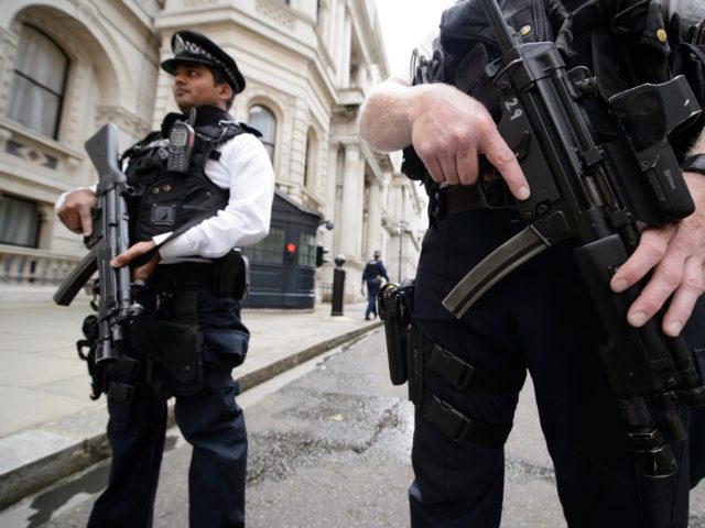 Armed police officers hold guns as they stand in Downing Street, in central London on August 29, 2014. British Home Secretary Theresa May said on August 29 the country's terror threat risk level was being raised to "severe" due to fears over the situation in Iraq and Syria. AFP PHOTO …