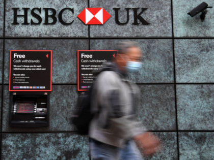 A pedestrian wearing a face mask or covering due to the COVID-19 pandemic, walks past a branch of a HSBC bank in central London on August 3, 2020. - HSBC on Monday revealed a 69-percent slump in net profits, joining a number of major bank whose earnings have been slammed …