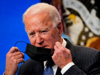 WASHINGTON, DC - JANUARY 25: U.S. President Joe Biden removes his face covering as he arri