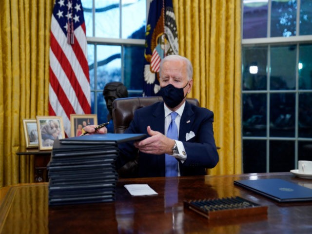 In this Jan. 20, 2021, file photo, President Joe Biden signs his first executive orders in the Oval Office of the White House in Washington. Six of Biden's 17 first-day executive orders dealt with immigration, such as halting work on a border wall in Mexico and lifting a travel ban …