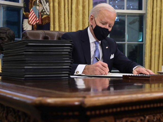 WASHINGTON, DC - JANUARY 20: U.S. President Joe Biden prepares to sign a series of executive orders at the Resolute Desk in the Oval Office just hours after his inauguration on January 20, 2021 in Washington, DC. Biden became the 46th president of the United States earlier today during the …