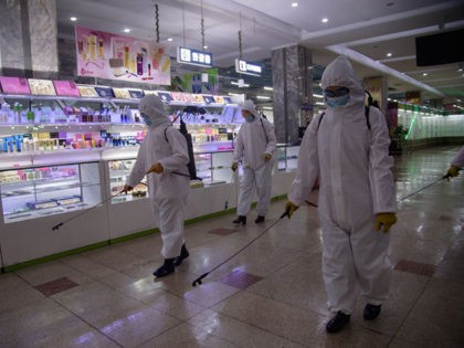 Health workers spray disinfectant inside the Pyongyang Department Store No. 1 prior to ope