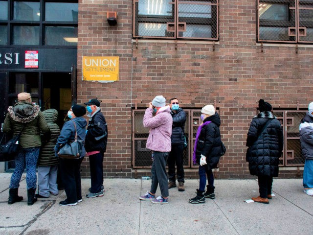 People wait in line for Pfizer Covid-19 vaccines at the opening of a new vaccination site at Corsi Houses in Harlem New York on January 15, 2021. - Pfizer expects lower coronavirus vaccine deliveries for a stretch beginning in late January in order to lift output later this winter and …