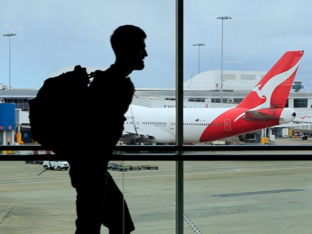 SYDNEY, AUSTRALIA - MARCH 10: A passenger walks past a Qantas jet at the International ter