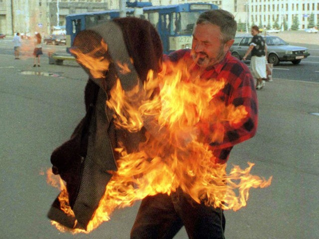 A man who identified himself as Nikolai Vasilenko pulls off his burning coat in the centra